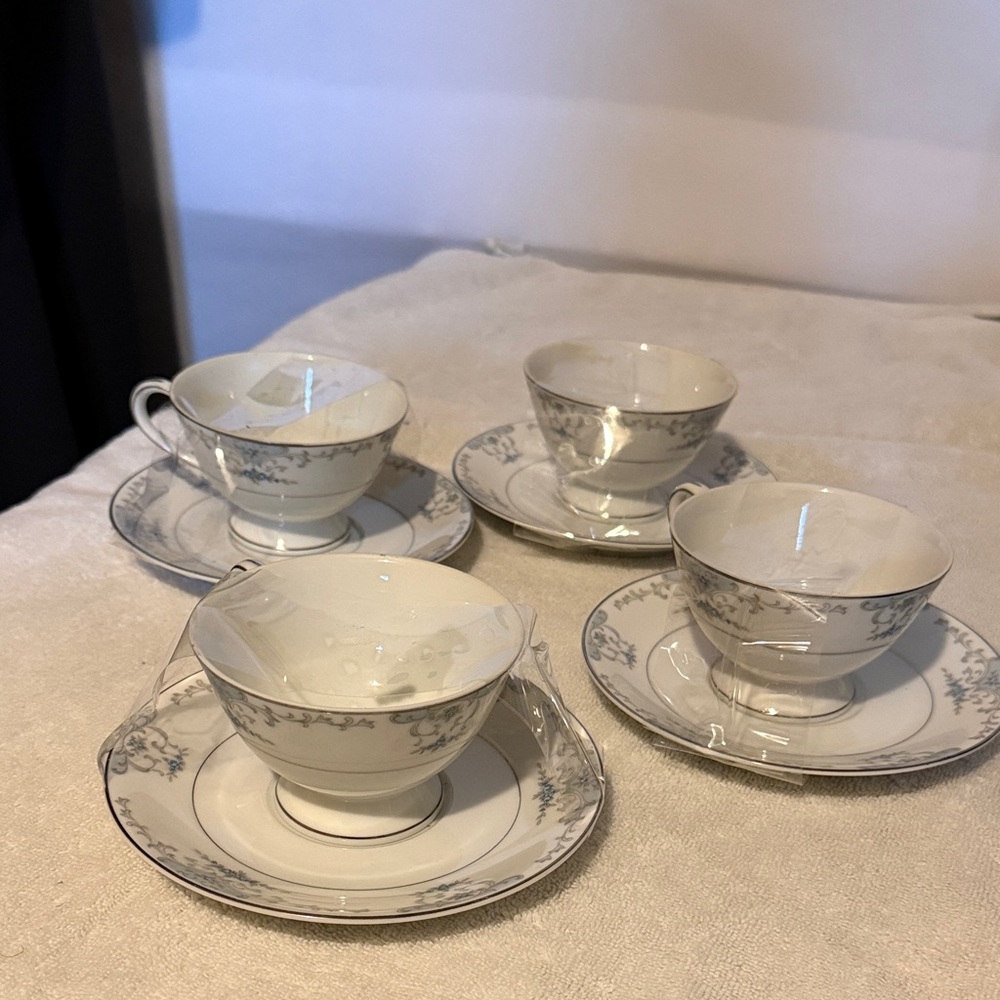Vintage teacups and saucers appear in the "Heirloom" pattern 4pc